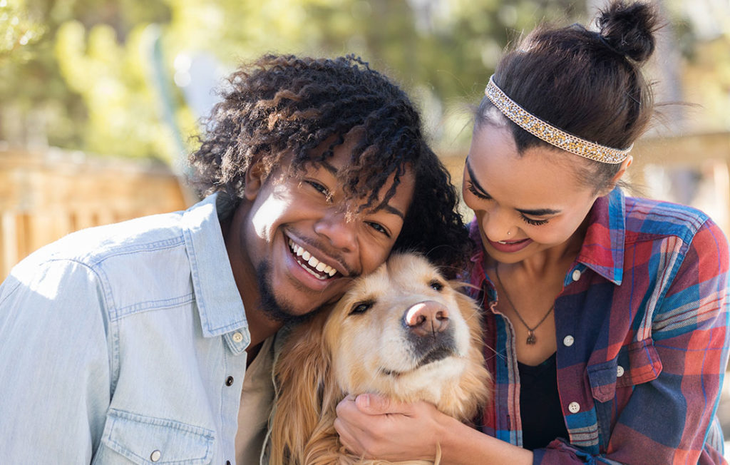 Young couple spend time playing with their cute dog Pic: Istockphoto