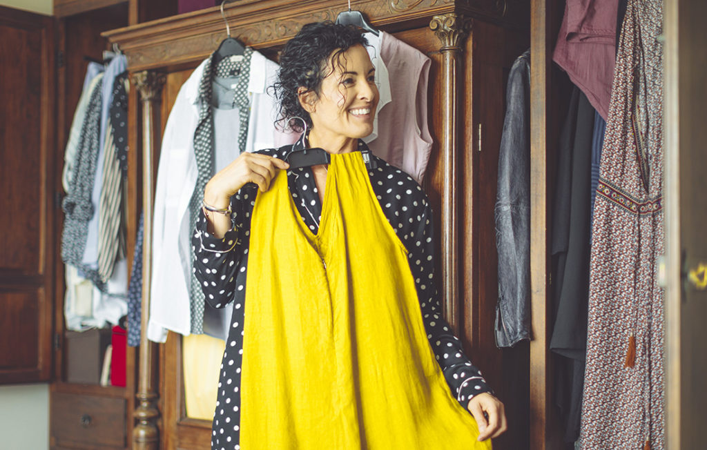 Lady trying on clothes from her wardrobe Pic: Istockphoto