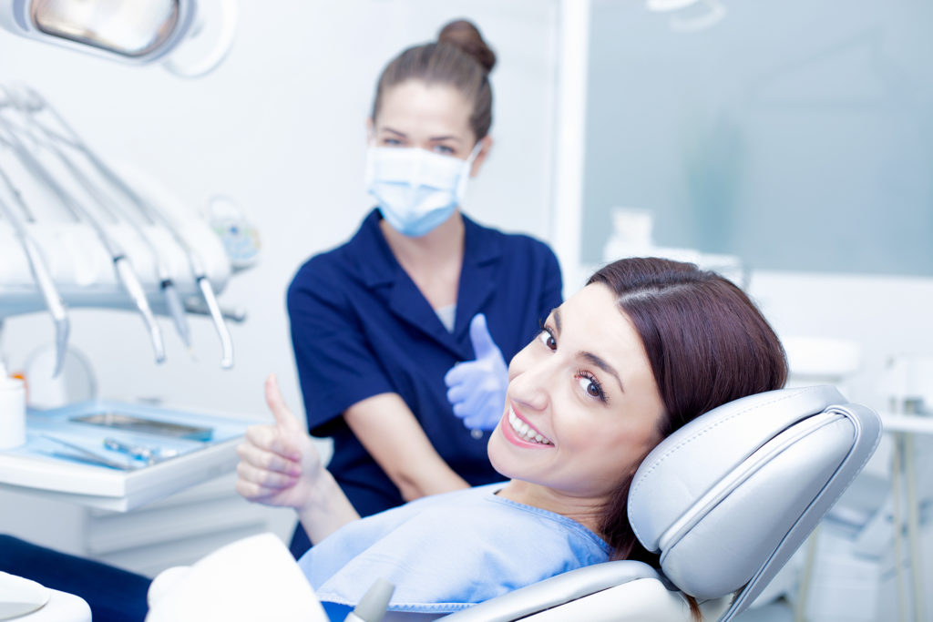 Woman in dentist's chair with dentist in background