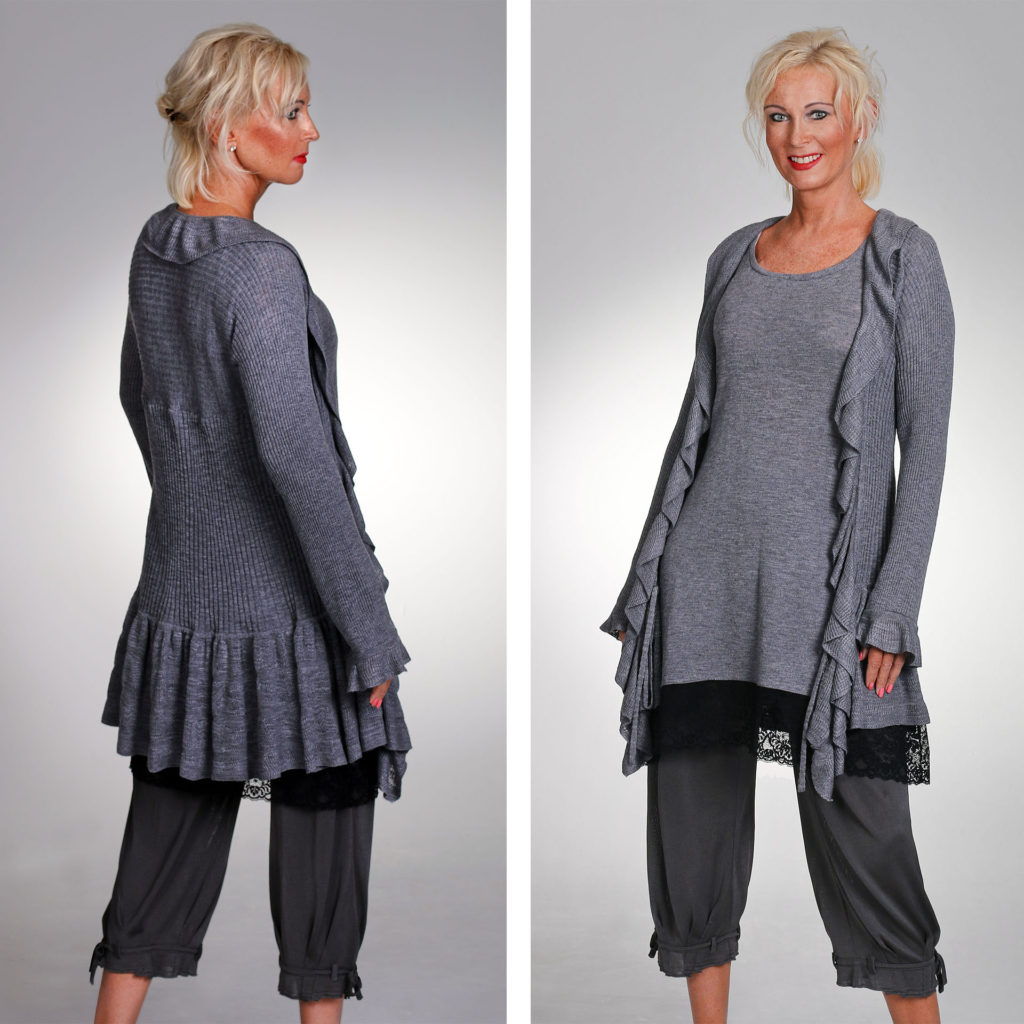 Front and back view of model in fine knit grey cardigan, deep knited frill around hem, shallower knitted frill around front edges and cuff