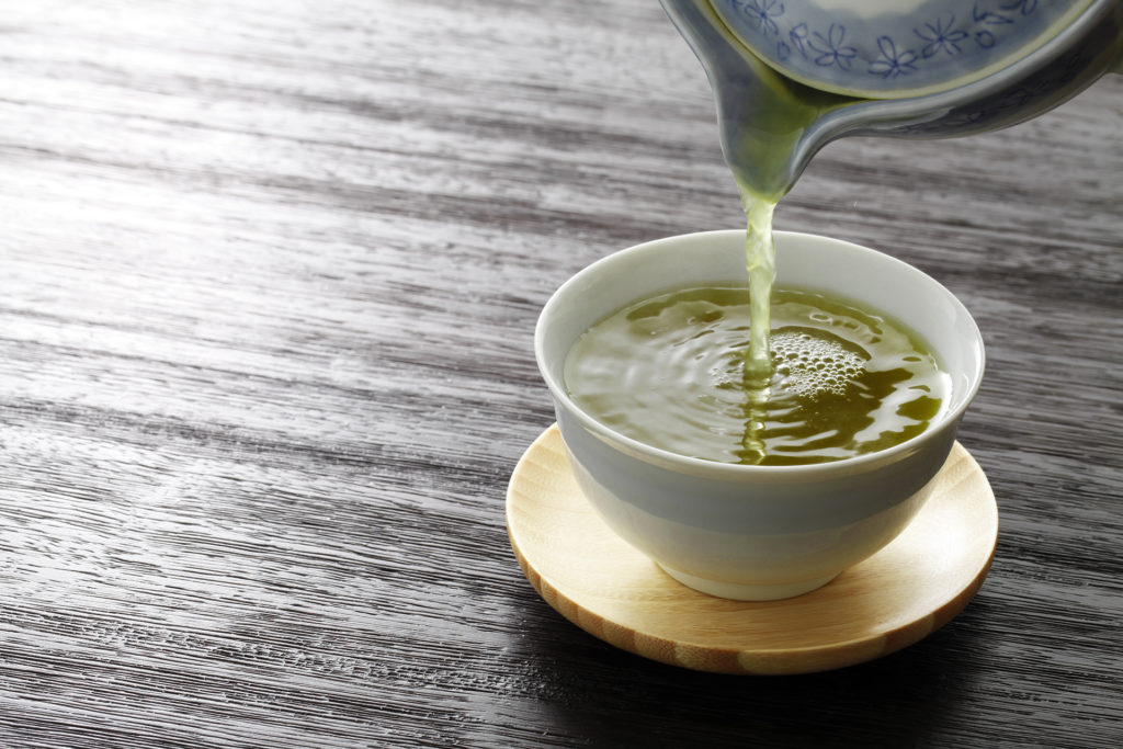 Green tea being poured into a cup