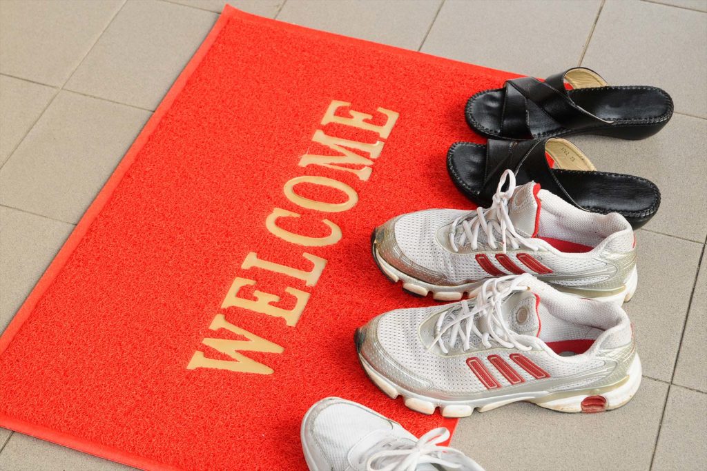 Pairs Of Shoes On A Welcome Mat