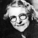 1958 photo of Georgina Landemare, smiling mature lady with grey hair pinned back and round glasses