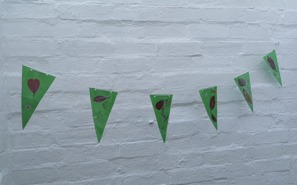 String of bunting hanging on white painted brick wall