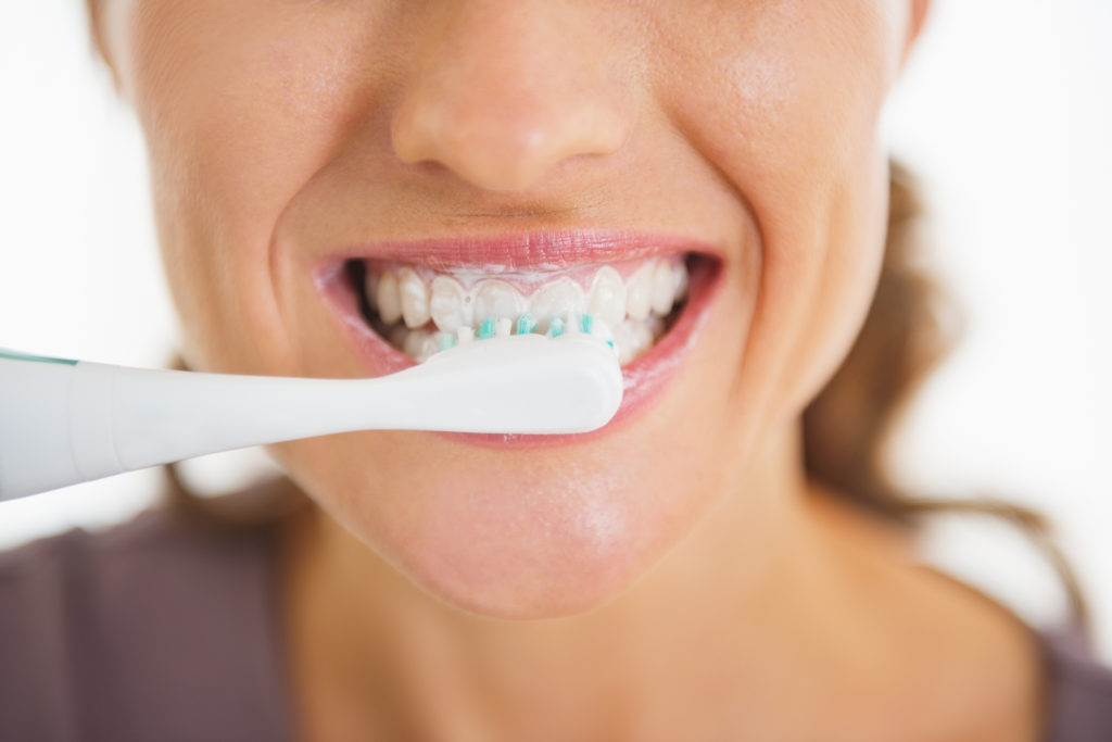 Closeup on happy woman brushing teeth; 