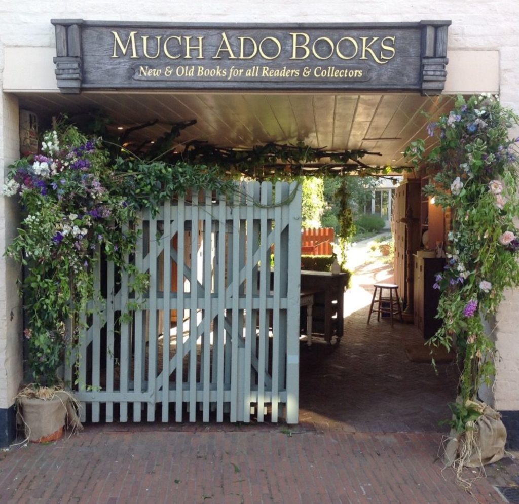 Much Ado bookshop entrance, with sage green painted wooden gate and plants around walls