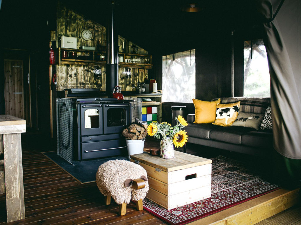 industrial/rustic interior with stove pipe, chunky wood, rug and child's sit-on sheep