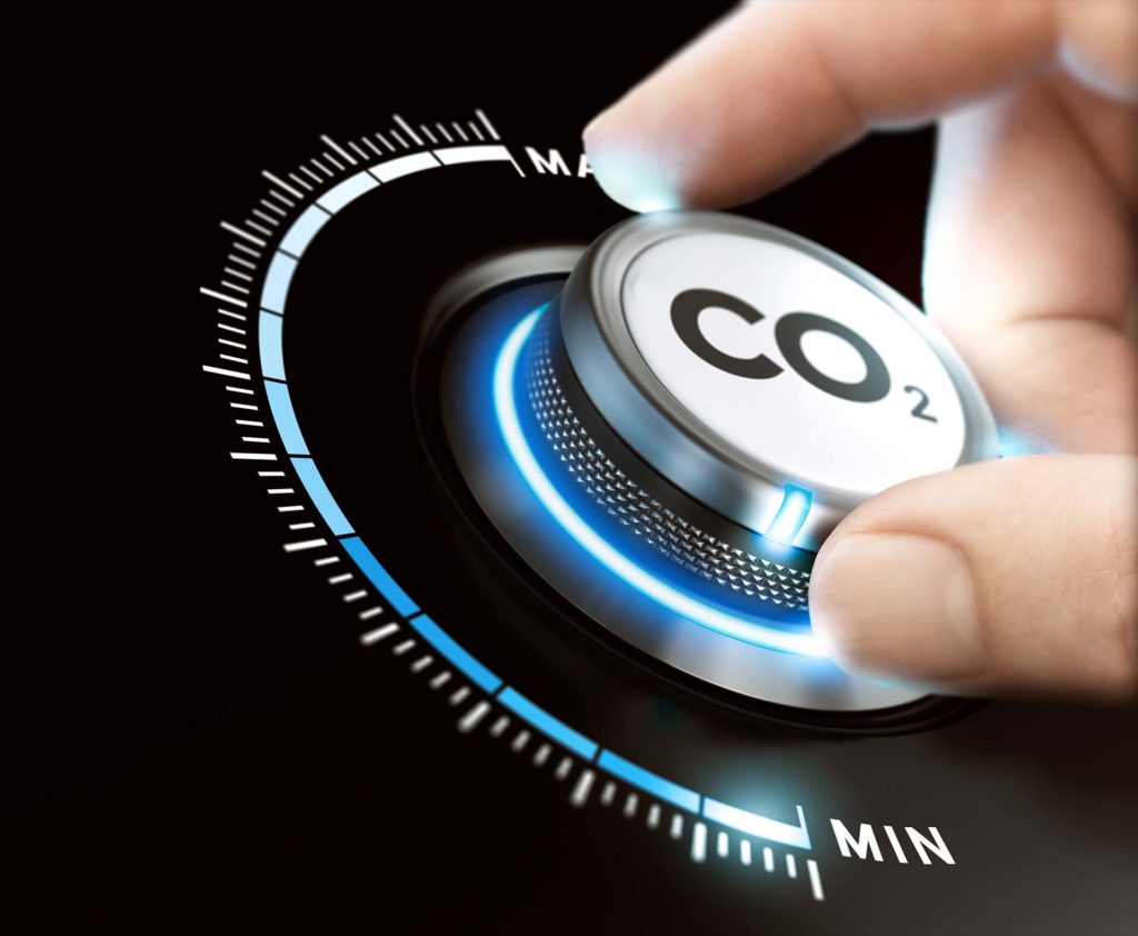 Man turning a carbon dioxide knob to reduce emissions. CO2 reduction or removal concept. Composite image between a hand photography and a 3D background.