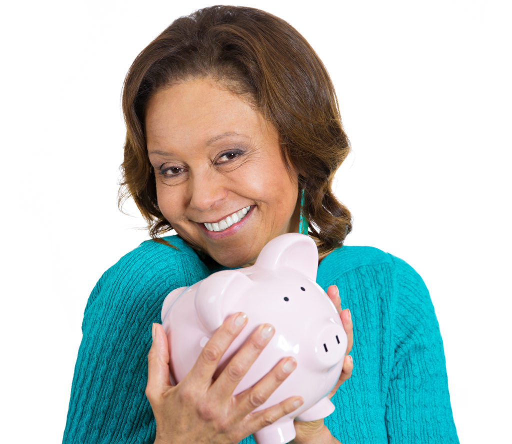 Mature woman cuddling piggy bank, smiling