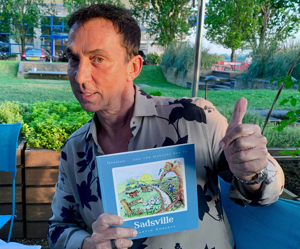 Bruno Tonioli holding the book and giving a thumbs up