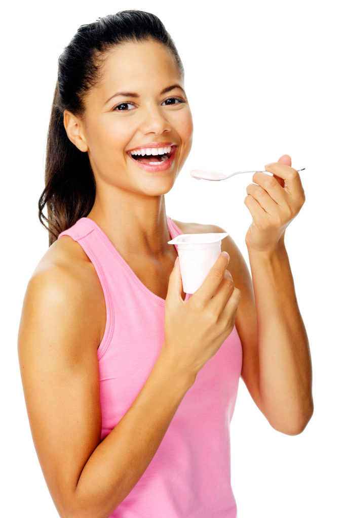 portrait of a friendly hispanic woman eating yoghurt promoting healthy lifestyle and dieting.