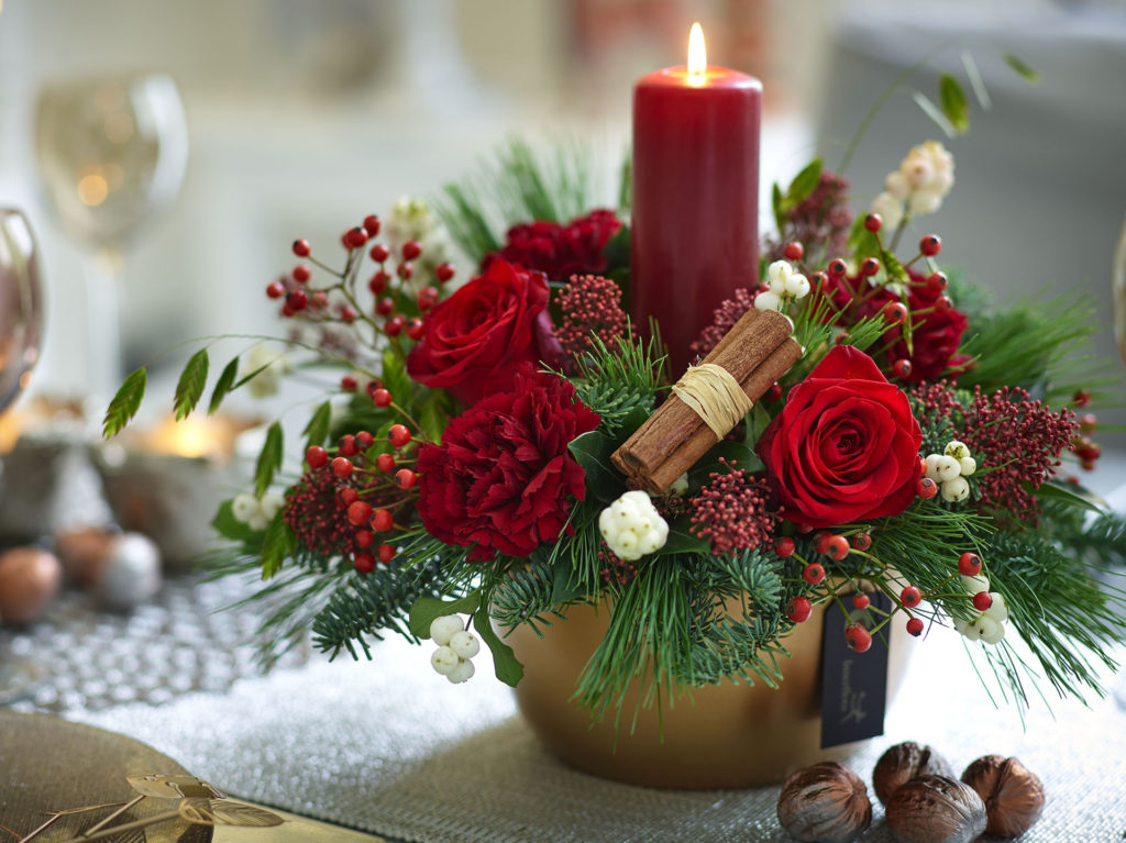 Red flowers in a candle arrangement