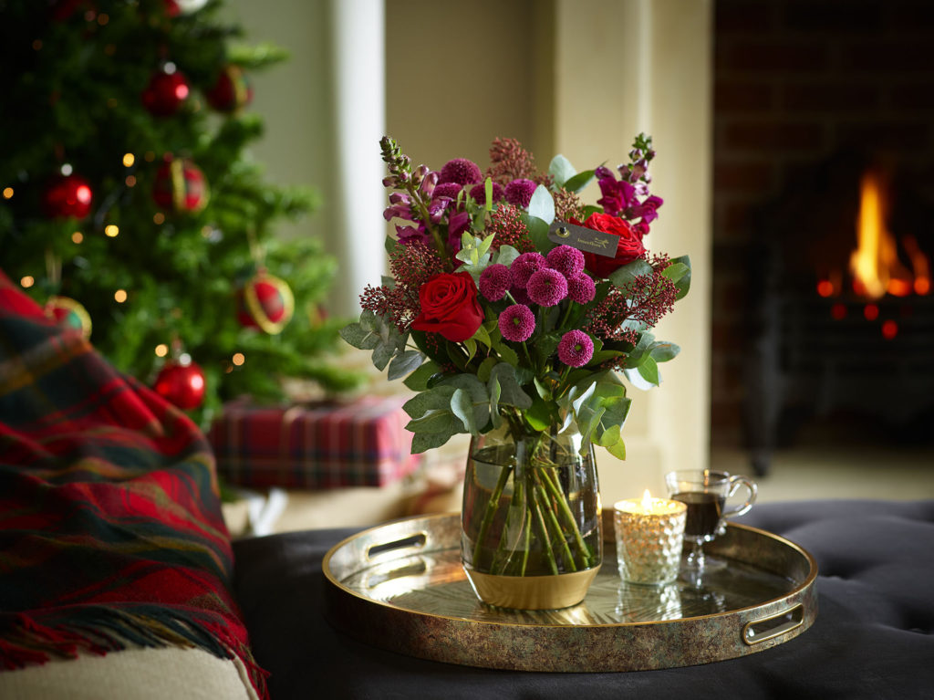 Bouquet of flowers in vase in Christmas decorated room