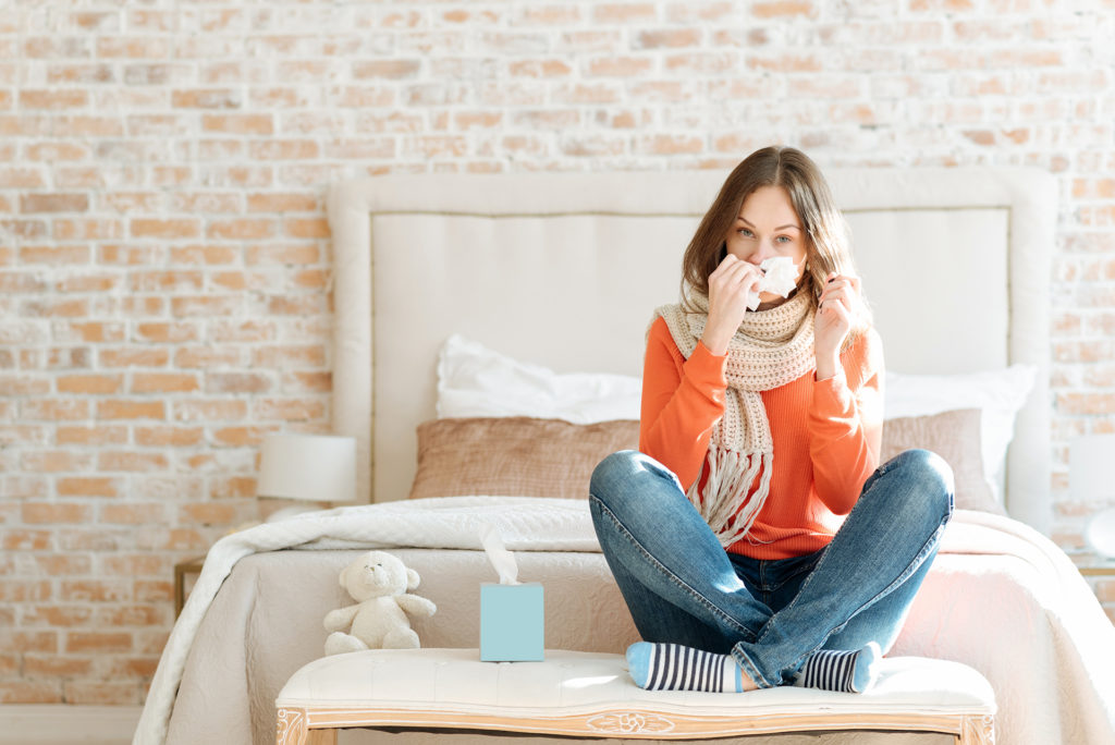 Upset young woman suffering from influenza at home; 
