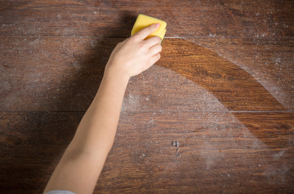 Using yellow sponge for cleaning dusty wood; 