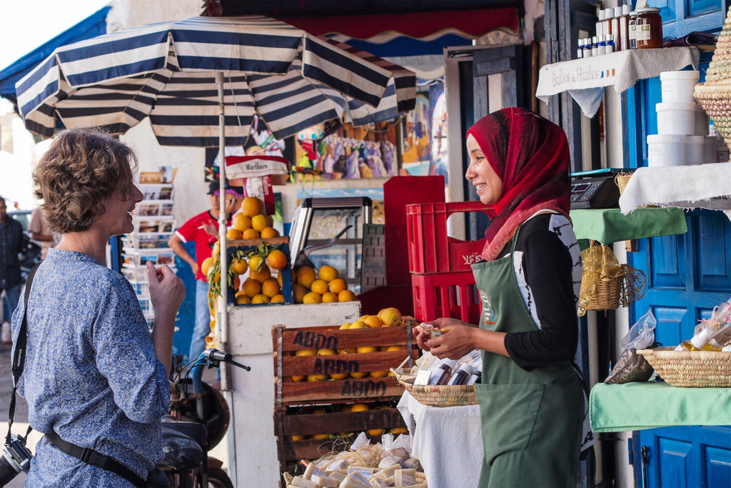 Woman tourist chatting to stallholder in Moroccan market, Rabat