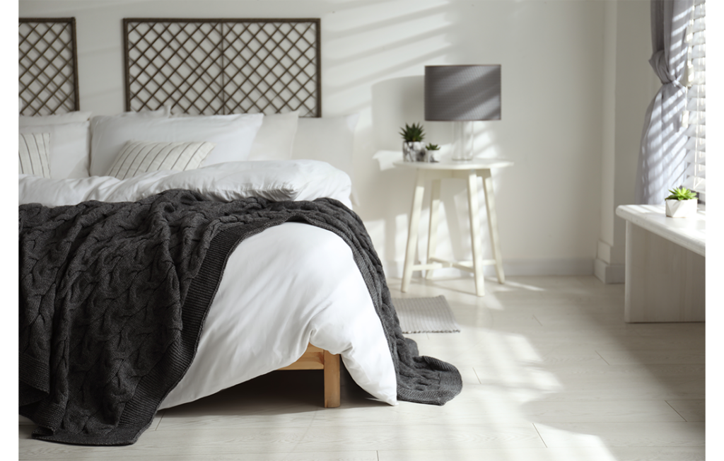 Bed with white linens and grey blanket